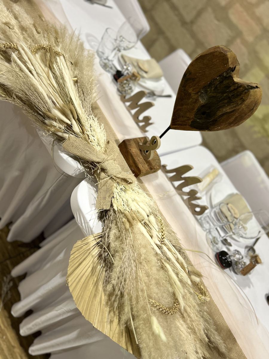 Table d'honneur ornée d'un cœur en bois et de fleurs séchées
