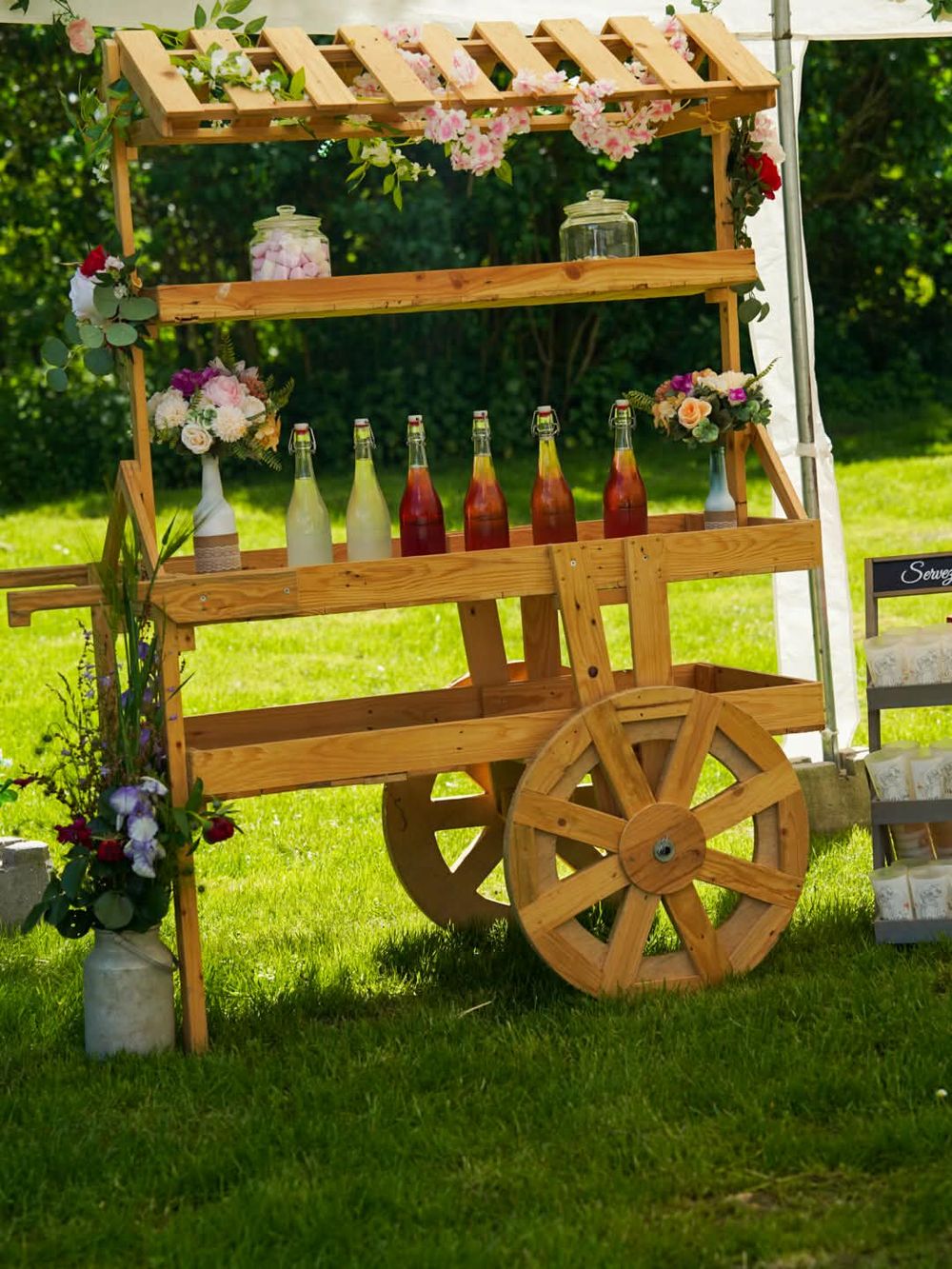 Bar à limonades installé dans une charrette en bois fleurie