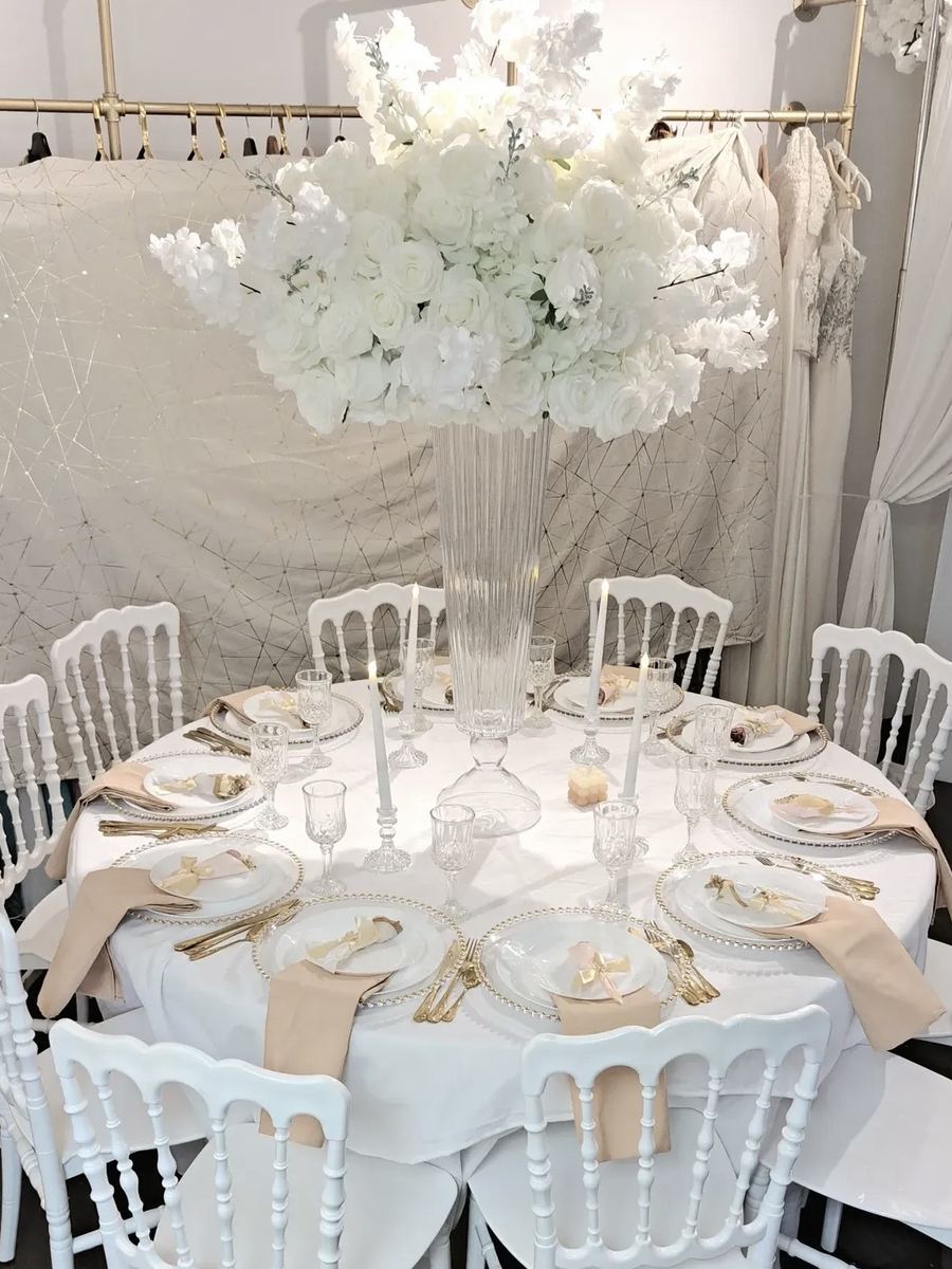 Table ronde dressée sous une suspension florale blanche