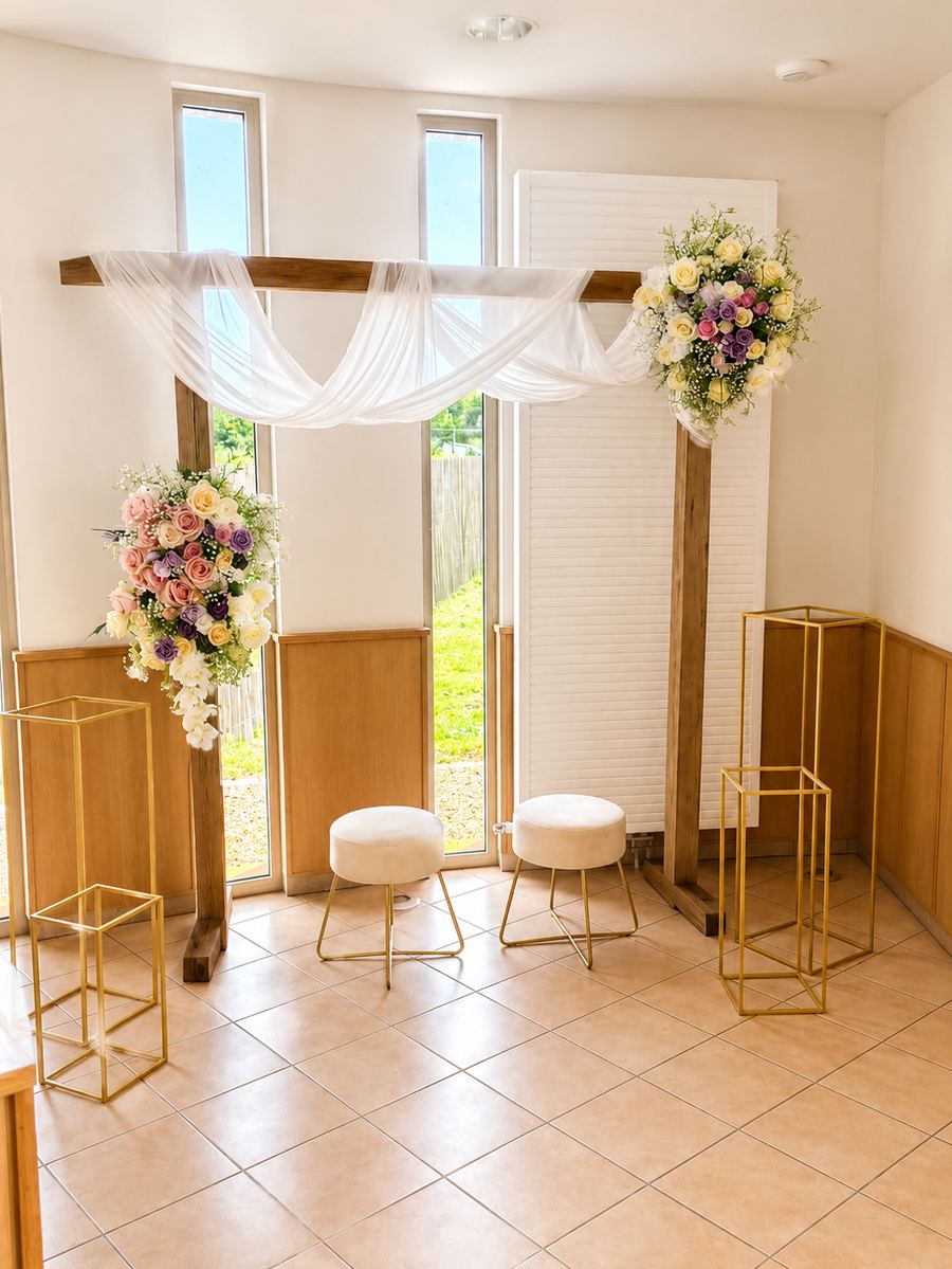 Arche de cérémonie en bois, voilage blanc et compositions florales pastel